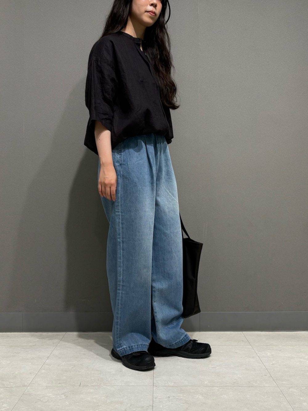 ブラック系のシャツ/ブラウス、ブラック系のトートバッグ、ブルー系のデニムパンツを着用したレディースの夏コーディネートの4枚目の写真