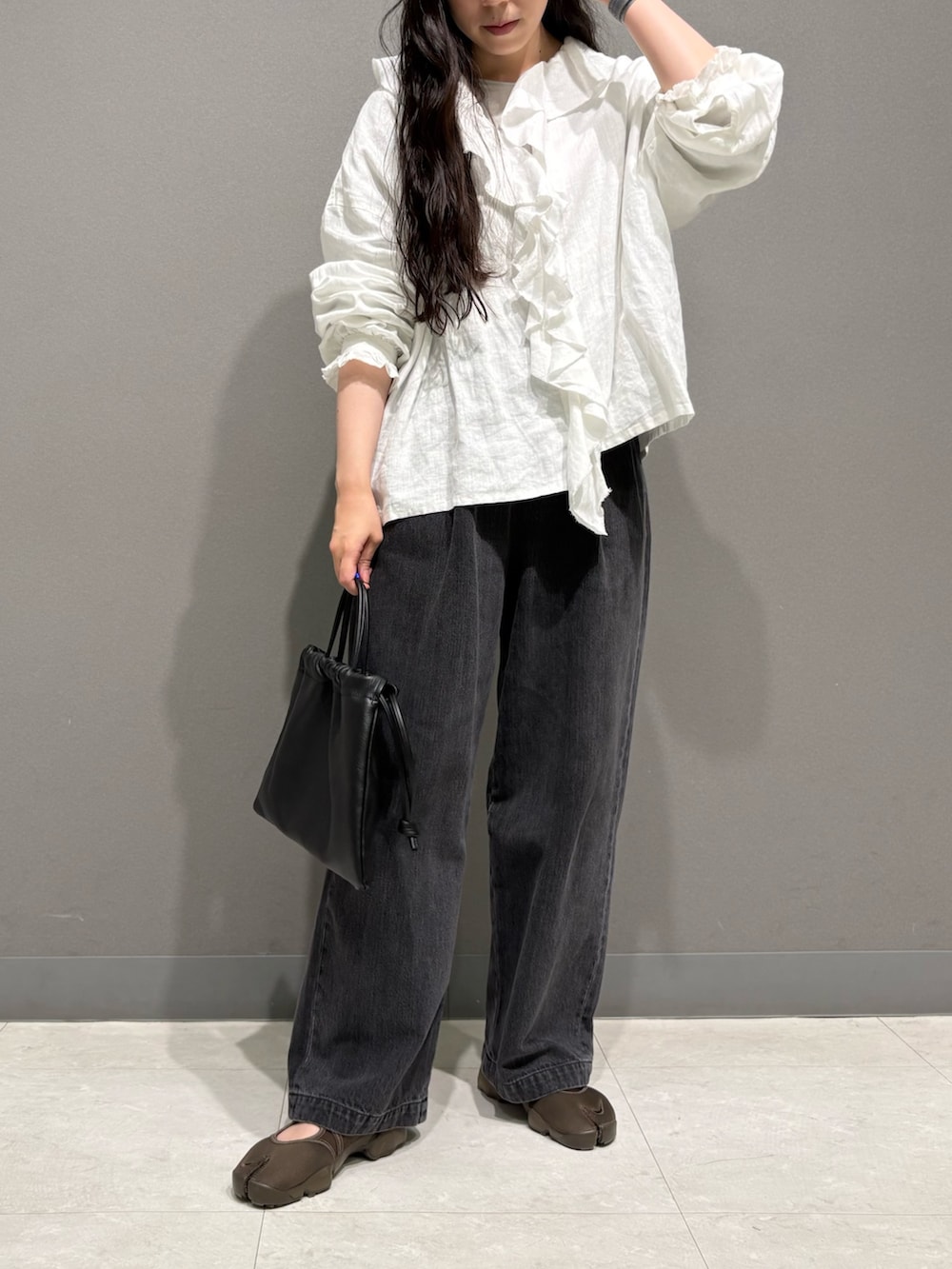 ホワイト系のシャツ/ブラウス、ブラック系のデニムパンツ、ブラウン系のスニーカーを着用したレディースの夏コーディネートの5枚目の写真