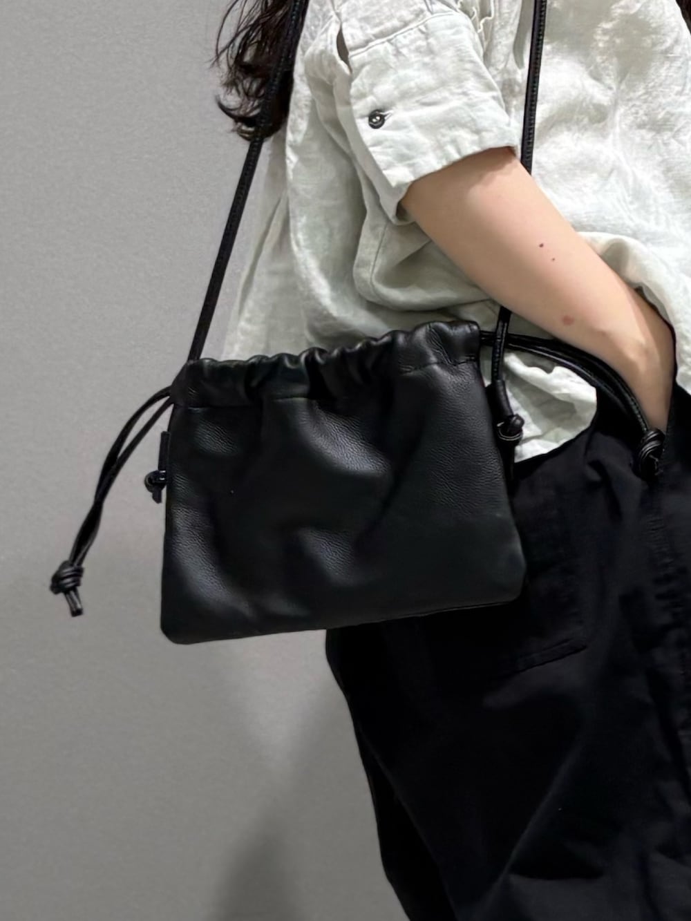 ブラック系のその他パンツ、ブラック系のショルダーバッグ、グレー系のシャツ/ブラウスを着用したレディースの春コーディネートの9枚目の写真
