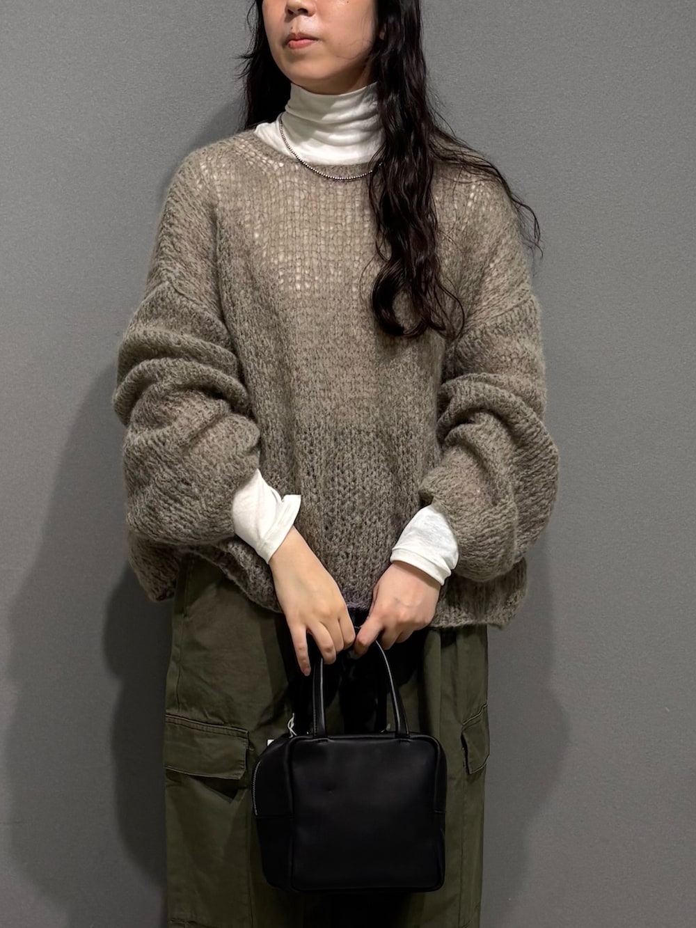 グレー系のニット/セーター、ホワイト系のTシャツ/カットソー、グリーン系のその他パンツを着用したレディースの秋コーディネートの5枚目の写真