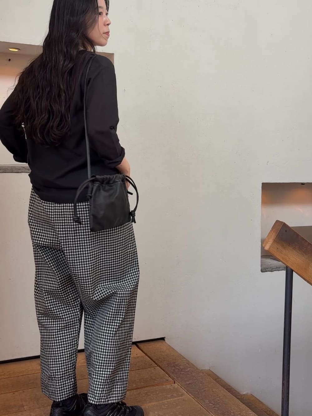 ブラック系のシャツ/ブラウス、ブラック系のショルダーバッグ、グレー系のネックレスを着用したレディースの夏コーディネートの5枚目の写真