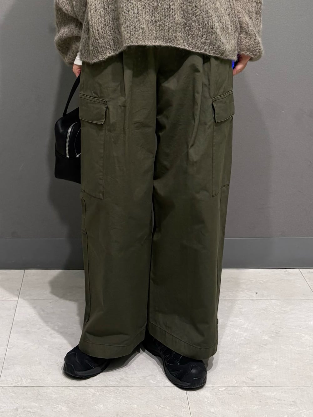 グレー系のニット/セーター、ホワイト系のTシャツ/カットソー、グリーン系のその他パンツを着用したレディースの秋コーディネートの9枚目の写真