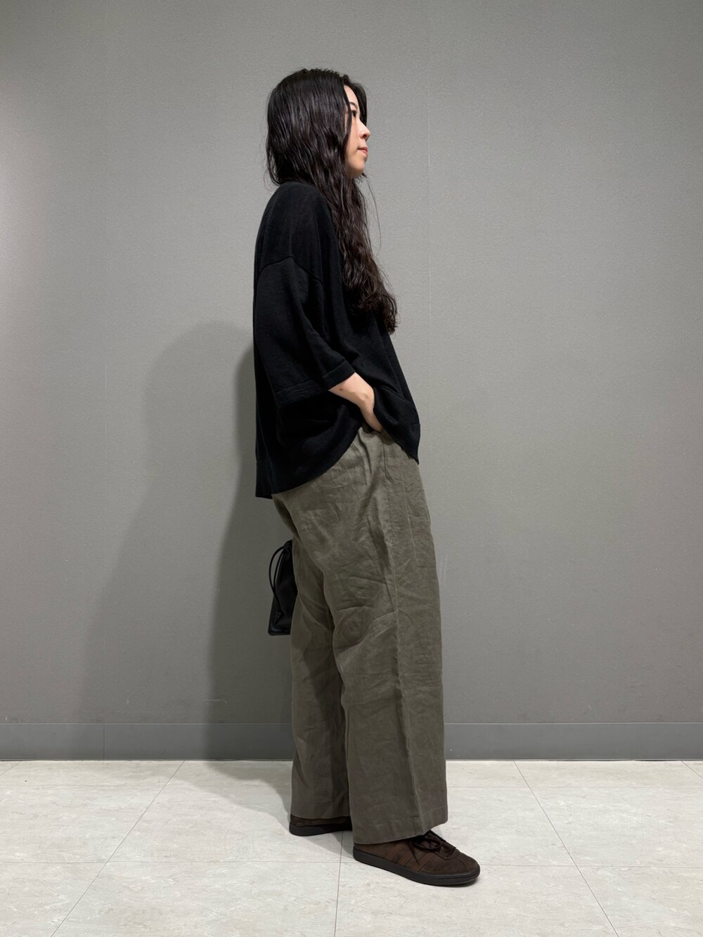 ベージュ系のその他パンツ、ブラック系のニット/セーター、ブラック系のその他雑貨を着用したレディースの夏コーディネートの5枚目の写真