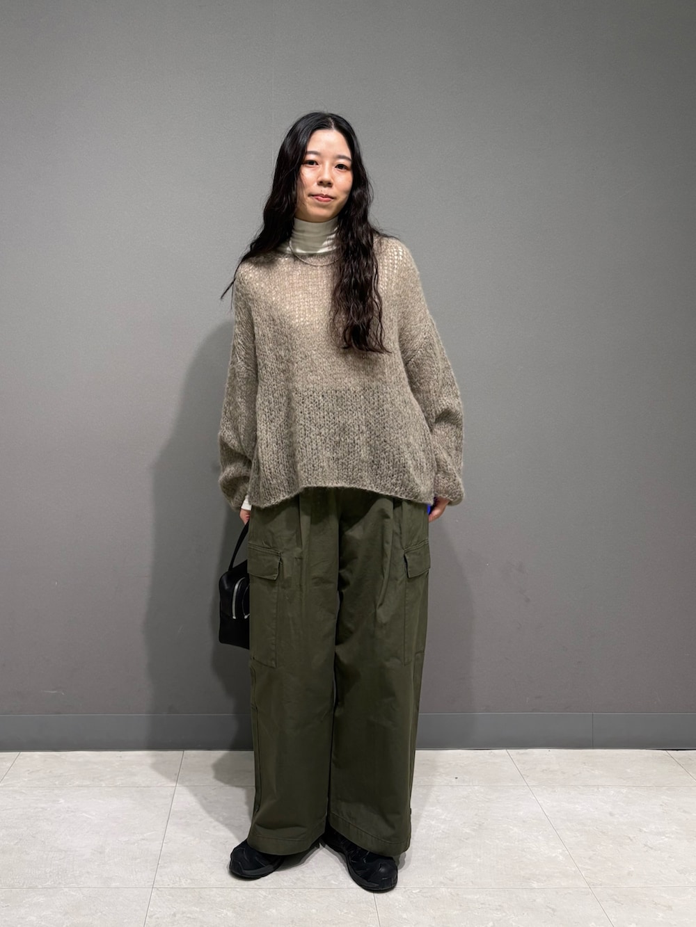 グレー系のニット/セーター、ホワイト系のTシャツ/カットソー、グリーン系のその他パンツを着用したレディースの秋コーディネートの3枚目の写真