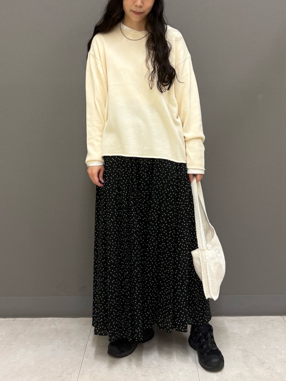 ホワイト系のニット/セーター、ホワイト系のTシャツ/カットソー、ブラック系のスカートを着用したレディースの秋コーディネートの2枚目の写真