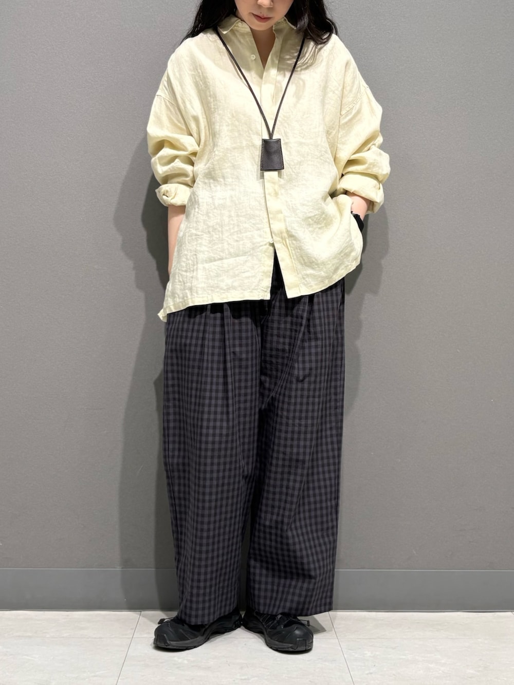 イエロー系のシャツ/ブラウス、グレー系のその他パンツ、ブラウン系のネックレスを着用したレディースの春コーディネートの2枚目の写真