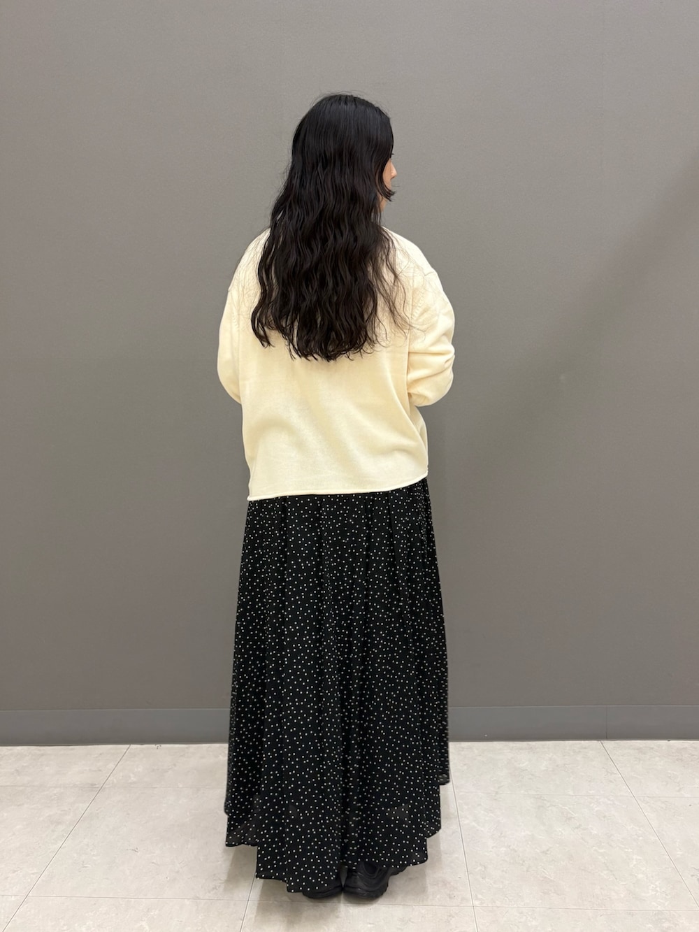 ホワイト系のニット/セーター、ホワイト系のTシャツ/カットソー、ブラック系のスカートを着用したレディースの秋コーディネートの8枚目の写真