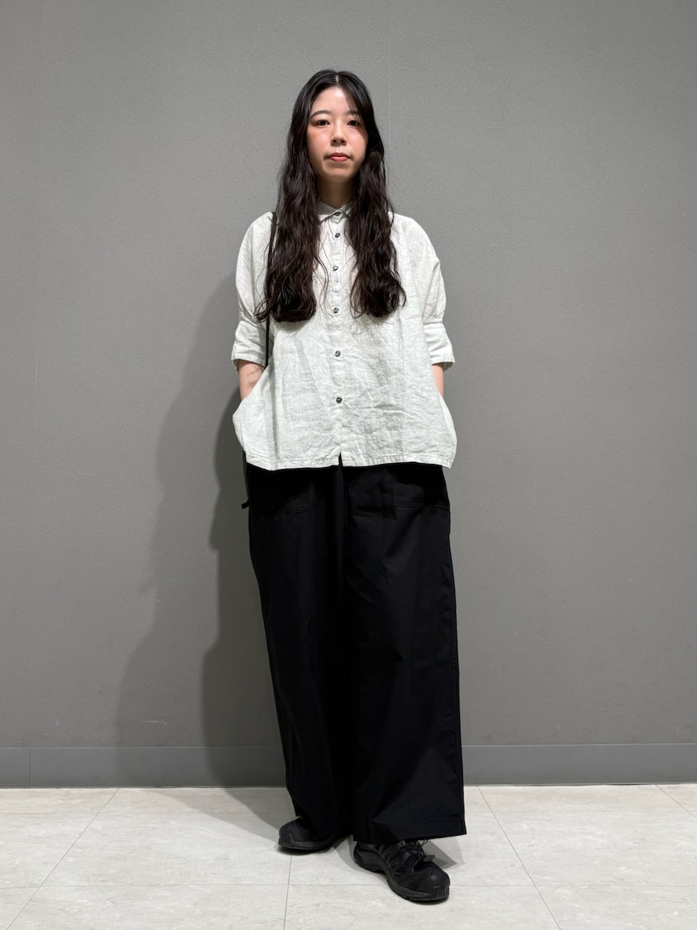 ブラック系のその他パンツ、ブラック系のショルダーバッグ、グレー系のシャツ/ブラウスを着用したレディースの春コーディネートの2枚目の写真