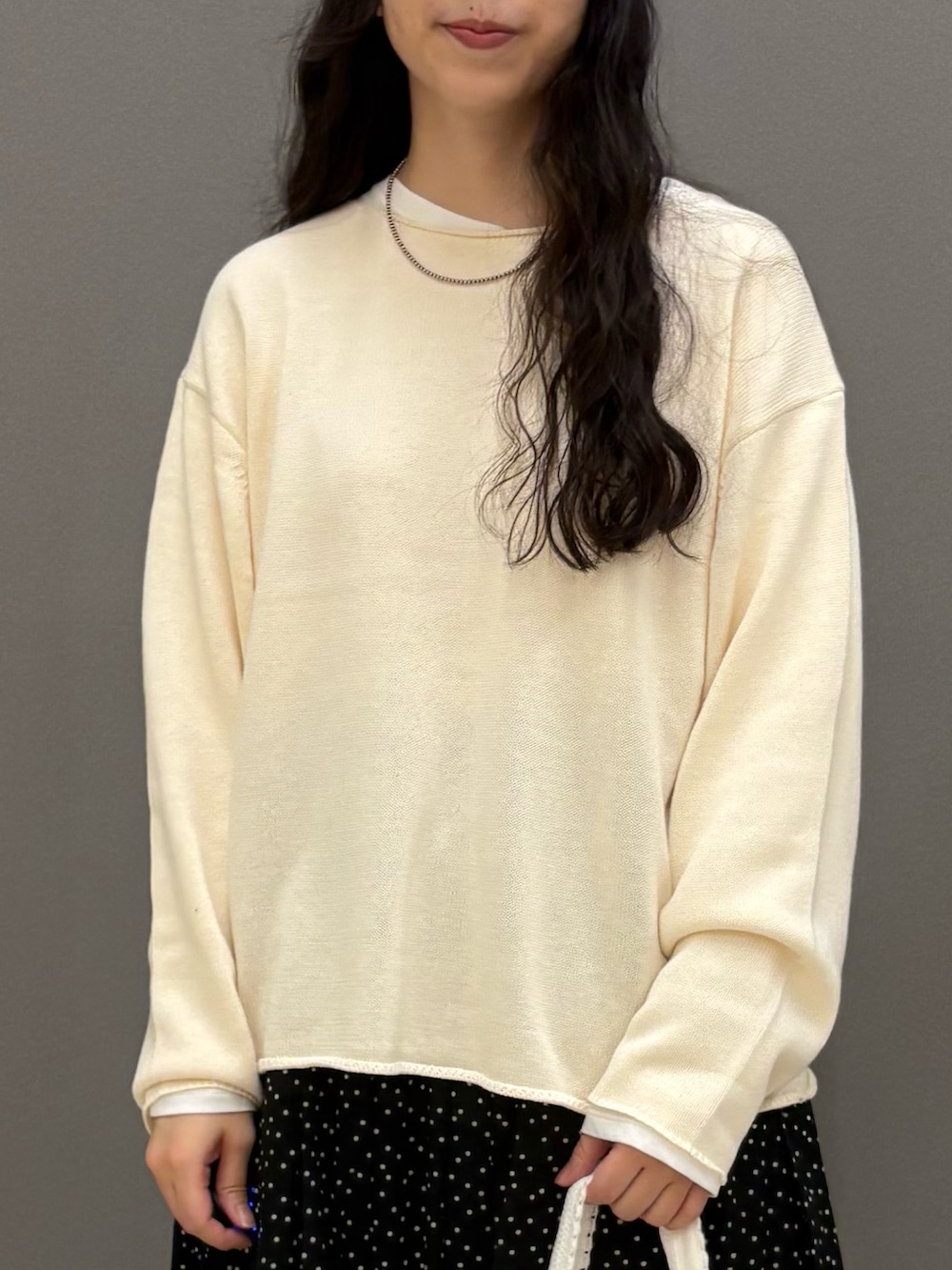 ホワイト系のニット/セーター、ホワイト系のTシャツ/カットソー、ブラック系のスカートを着用したレディースの秋コーディネートの3枚目の写真