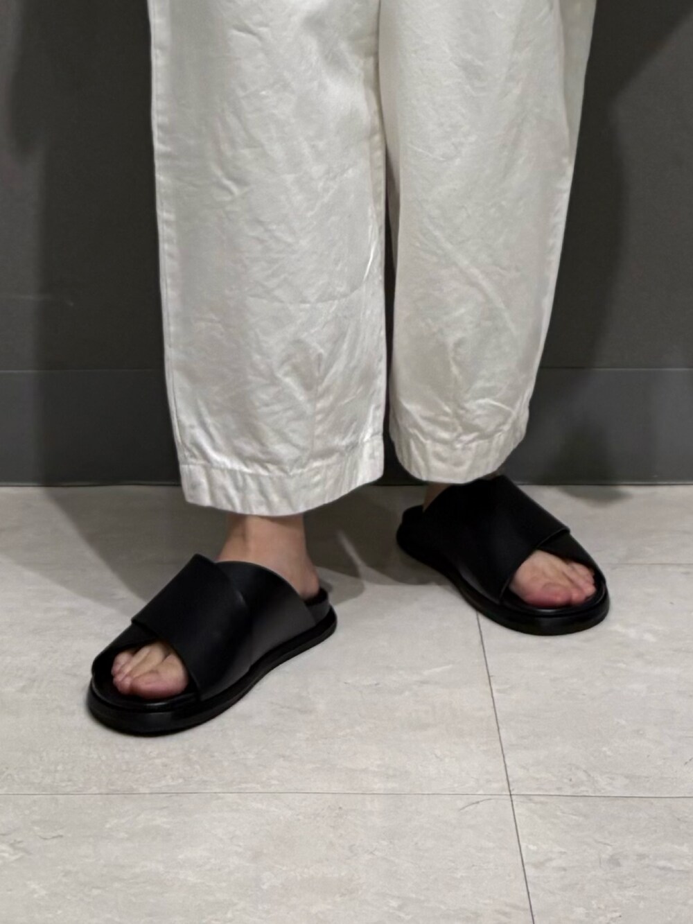 グレー系のTシャツ/カットソー、ブラック系のカーディガン/ボレロ、ホワイト系のその他パンツを着用したレディースの夏コーディネートの6枚目の写真