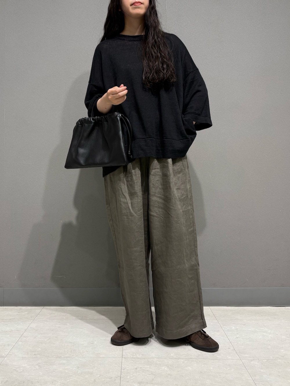 ベージュ系のその他パンツ、ブラック系のニット/セーター、ブラック系のその他雑貨を着用したレディースの夏コーディネートの3枚目の写真