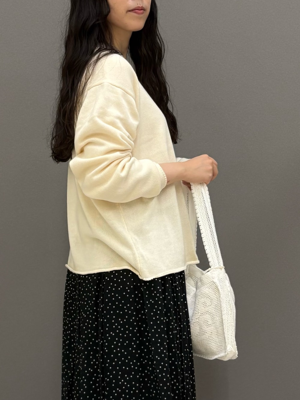 ホワイト系のニット/セーター、ホワイト系のTシャツ/カットソー、ブラック系のスカートを着用したレディースの秋コーディネートの6枚目の写真