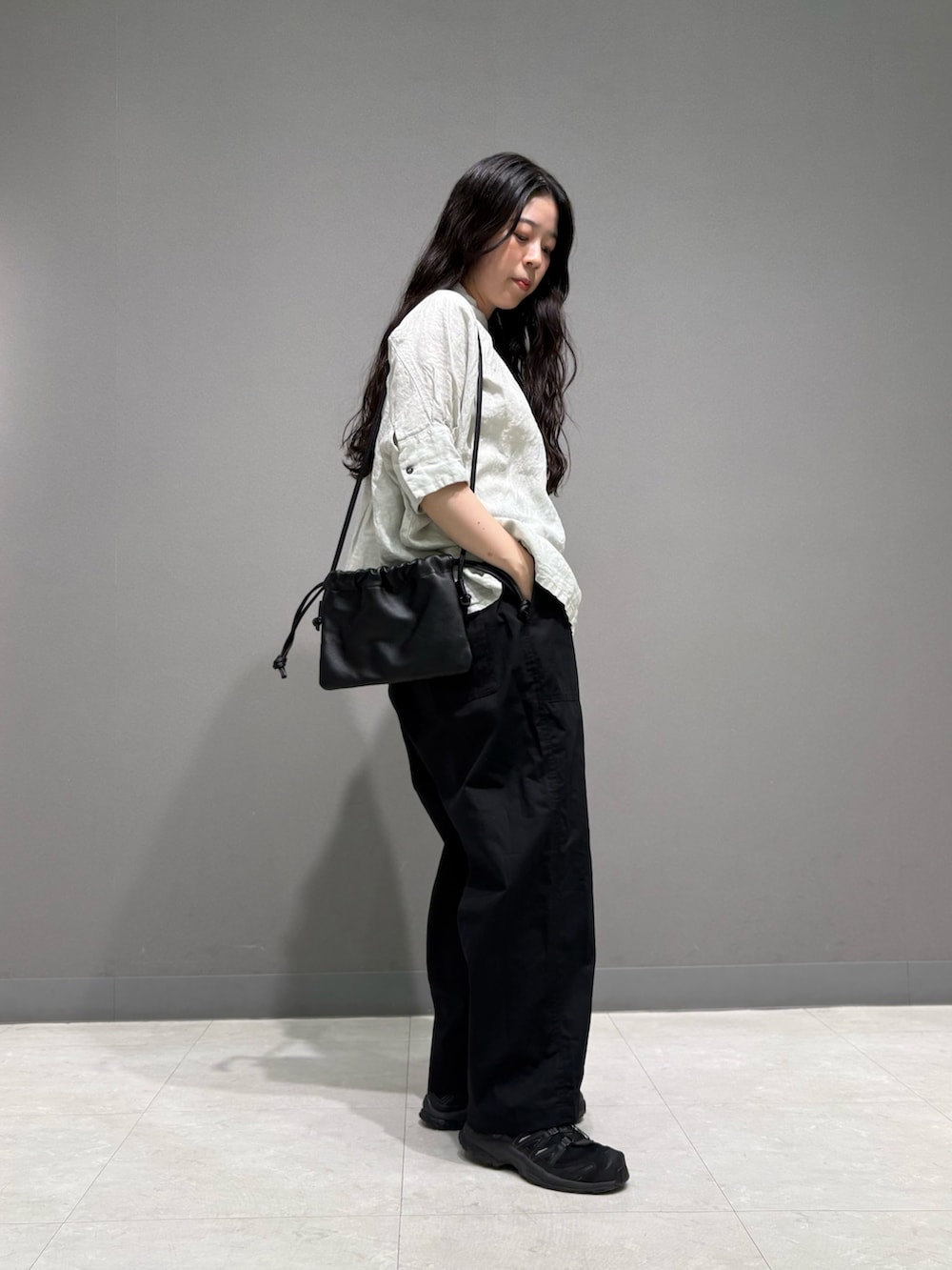 ブラック系のその他パンツ、ブラック系のショルダーバッグ、グレー系のシャツ/ブラウスを着用したレディースの春コーディネートの6枚目の写真
