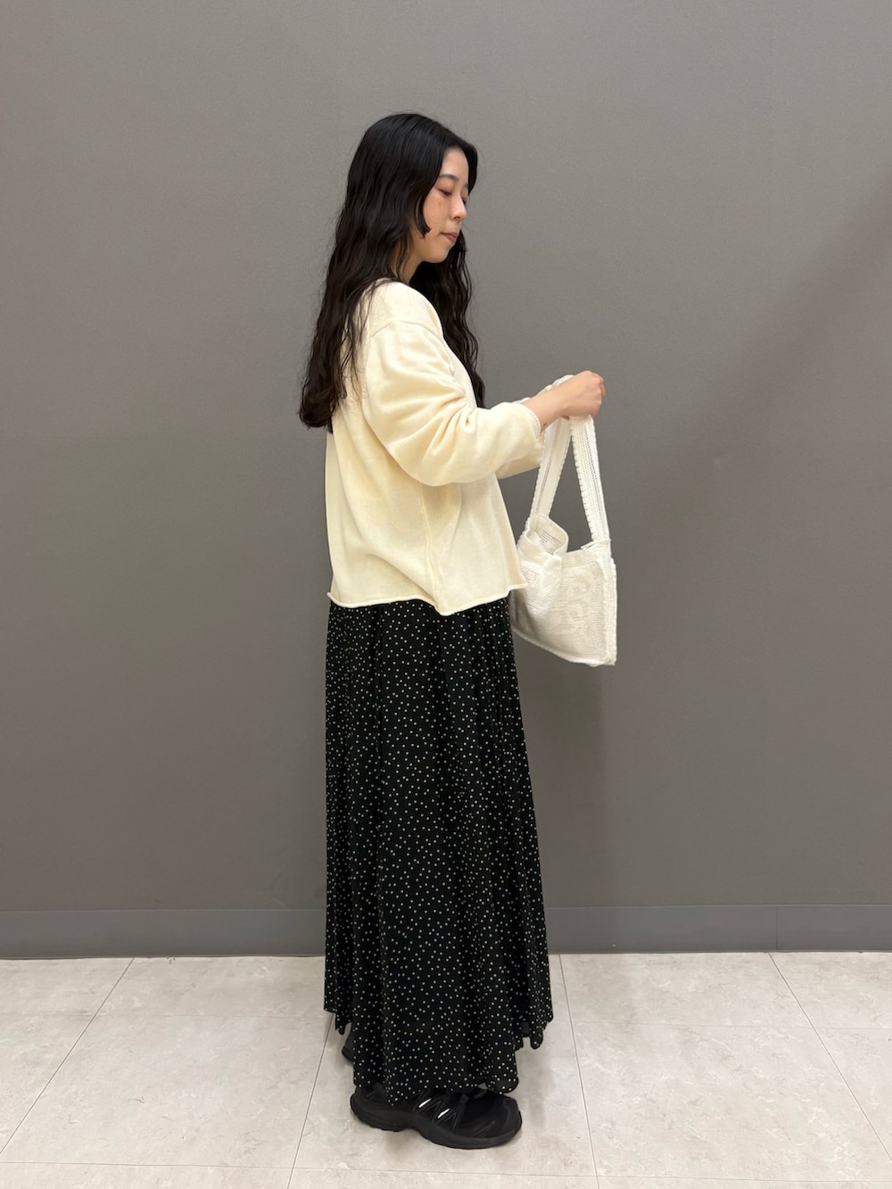 ホワイト系のニット/セーター、ホワイト系のTシャツ/カットソー、ブラック系のスカートを着用したレディースの秋コーディネートの4枚目の写真