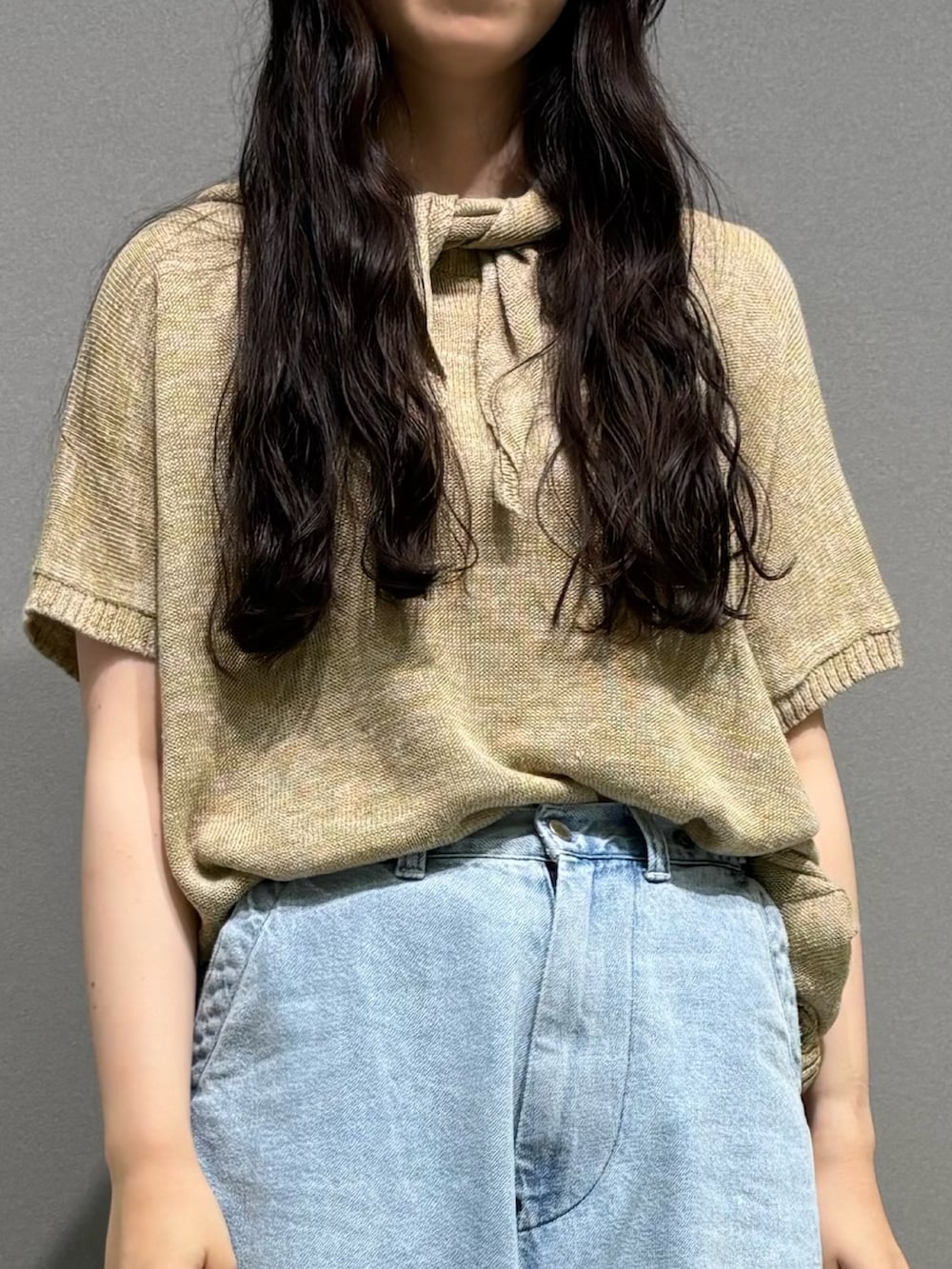 ブルー系のデニムパンツ、イエロー系のニット/セーターを着用したレディースの夏コーディネートの3枚目の写真