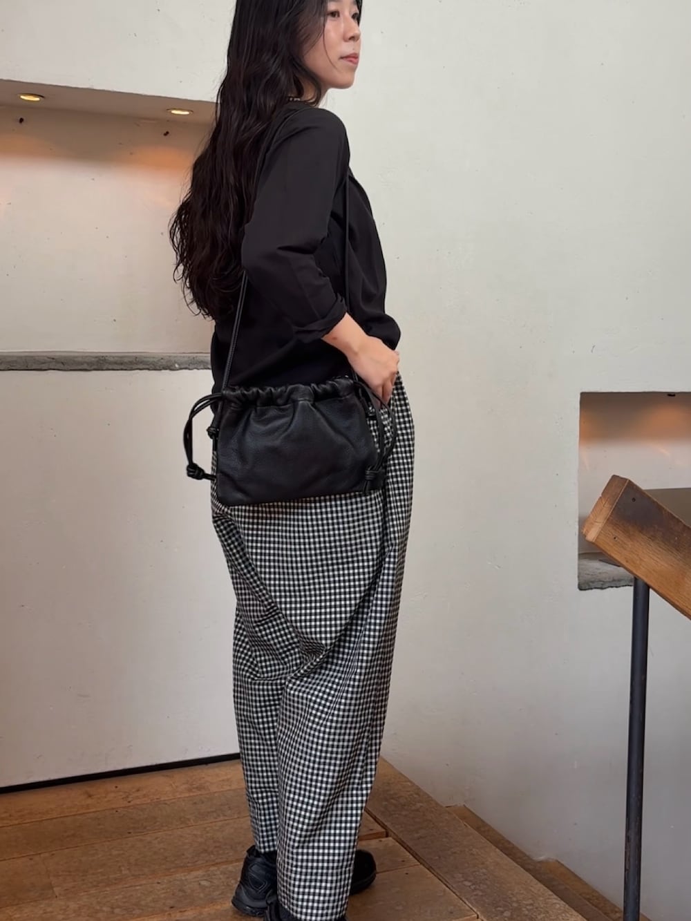 ブラック系のシャツ/ブラウス、ブラック系のショルダーバッグ、グレー系のネックレスを着用したレディースの夏コーディネートの3枚目の写真