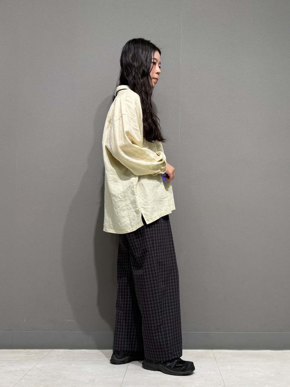 イエロー系のシャツ/ブラウス、グレー系のその他パンツ、ブラウン系のネックレスを着用したレディースの春コーディネートの3枚目の写真