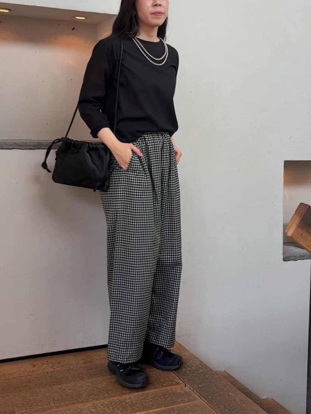 ブラック系のシャツ/ブラウス、ブラック系のショルダーバッグ、グレー系のネックレスを着用したレディースの夏コーディネートの2枚目の写真