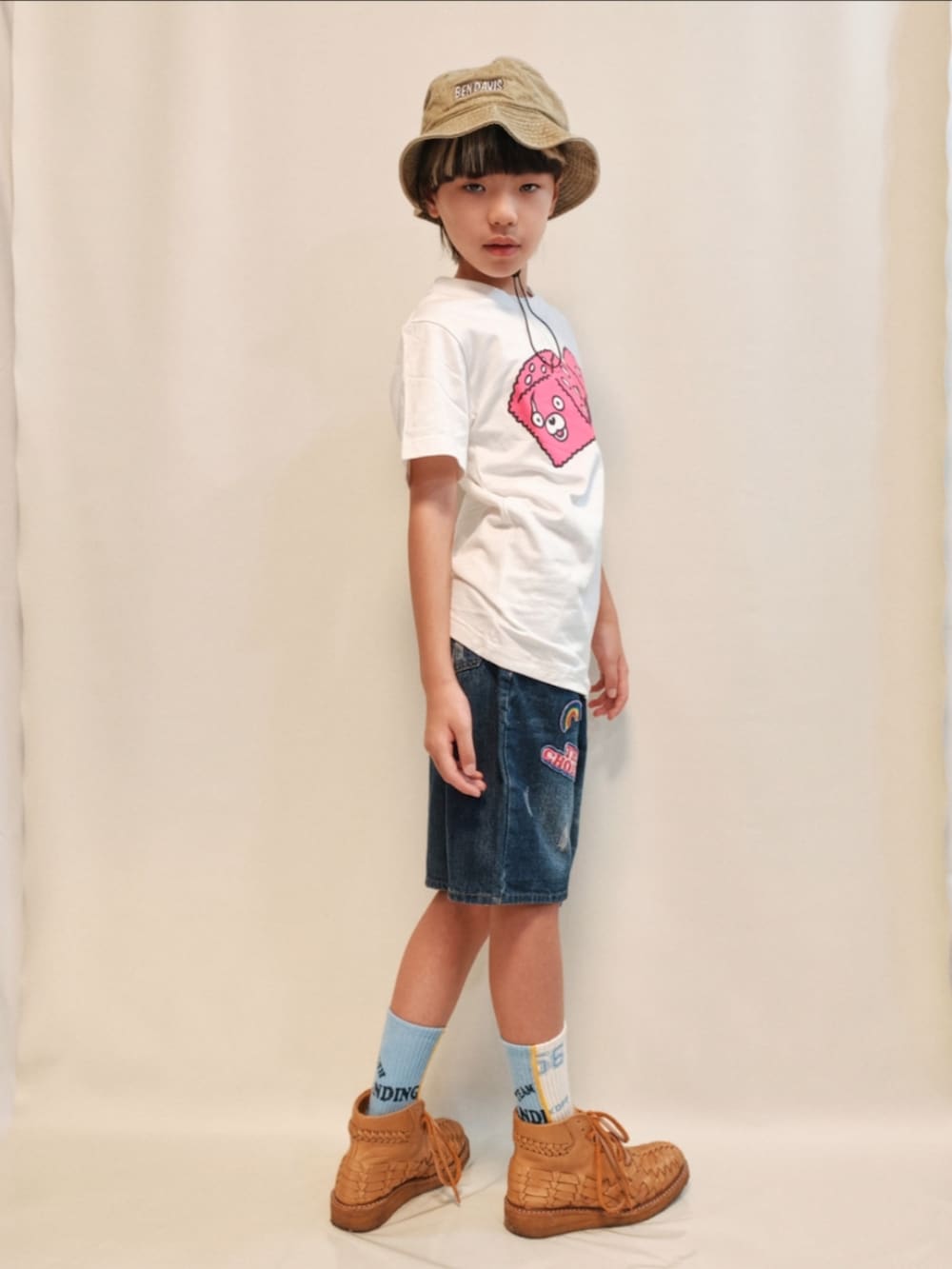ブルー系のデニムパンツ、ベージュ系のブーツ、ホワイト系のTシャツ/カットソーを着用したキッズの夏コーディネートの3枚目の写真