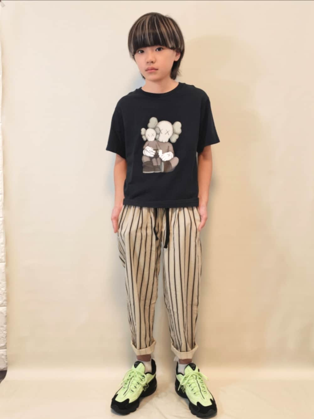 グリーン系のスニーカー、ベージュ系のその他パンツ、ブラック系のTシャツ/カットソーを着用したキッズの秋コーディネートの2枚目の写真