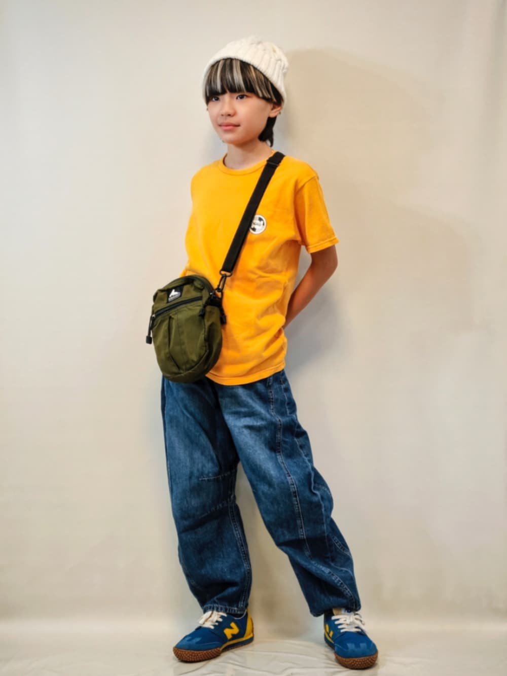 イエロー系のTシャツ/カットソー、ブルー系のデニムパンツ、ブルー系のスニーカーを着用したキッズの秋コーディネートの2枚目の写真