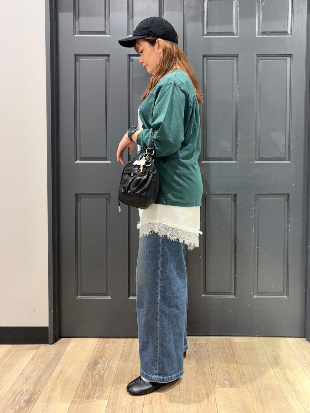 グリーン系のTシャツ/カットソー、ブラック系のショルダーバッグ、ホワイト系のベルトを着用したレディースの秋コーディネートの2枚目の写真