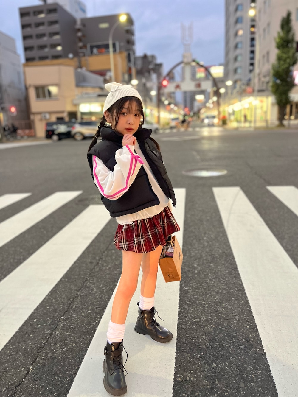 ブラック系のダウンベスト、レッド系のスカートを着用したキッズの秋コーディネートの3枚目の写真