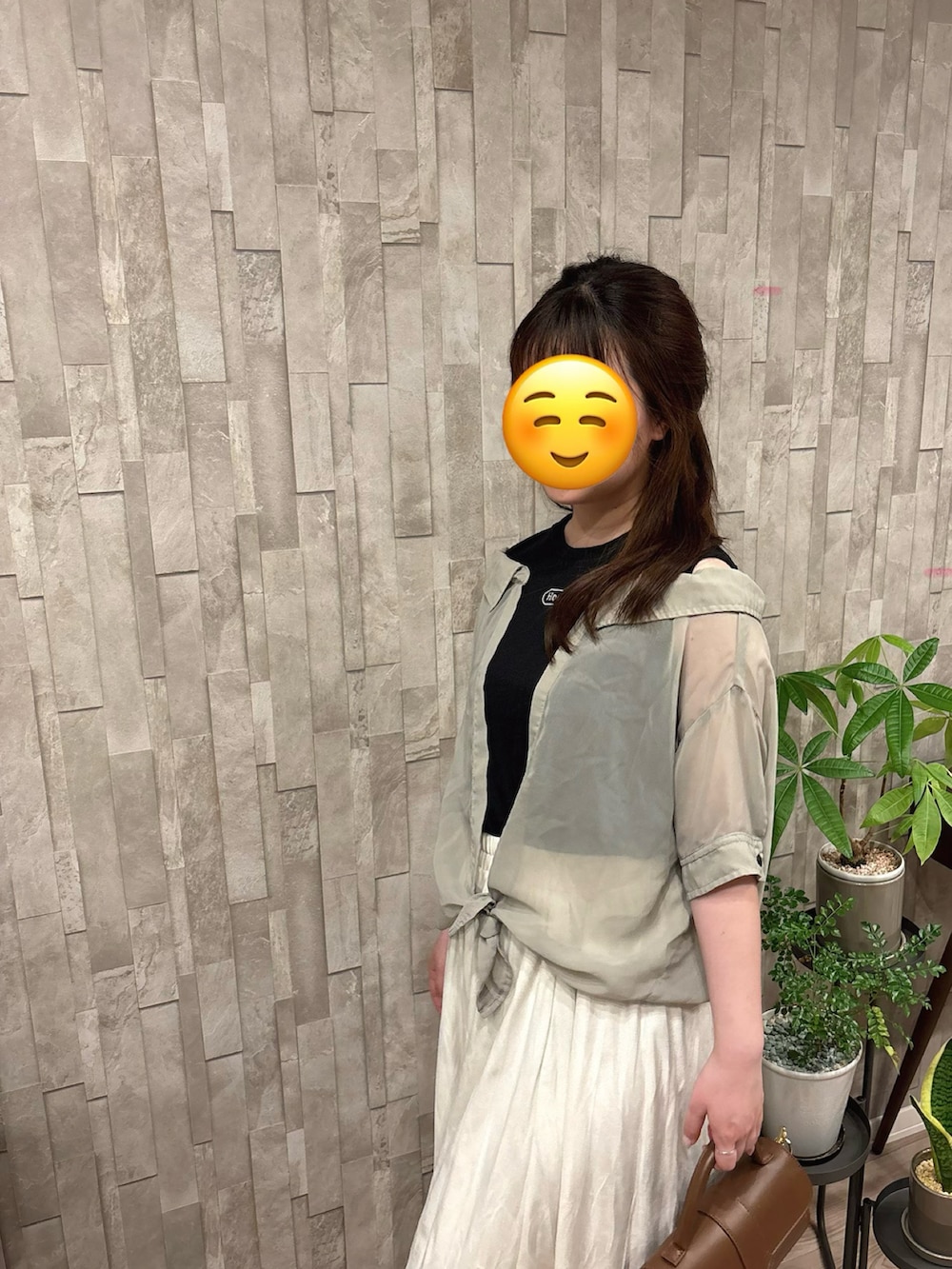 グリーン系のトップスを着用したレディースの春コーディネートの2枚目の写真