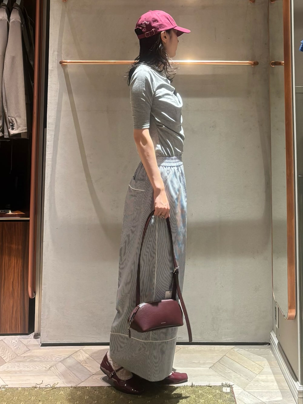 ブルー系のその他パンツ、グレー系のTシャツ/カットソー、レッド系のキャップを着用したレディースの秋コーディネートの2枚目の写真