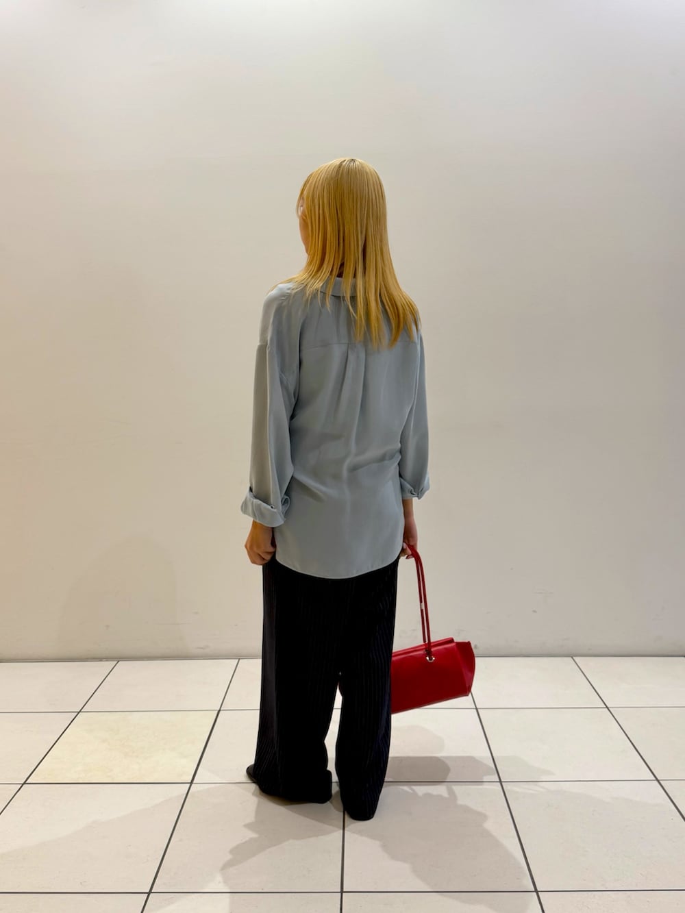ブルー系のシャツ/ブラウス、ホワイト系のタンクトップ、レッド系のショルダーバッグを着用したレディースの秋コーディネートの3枚目の写真