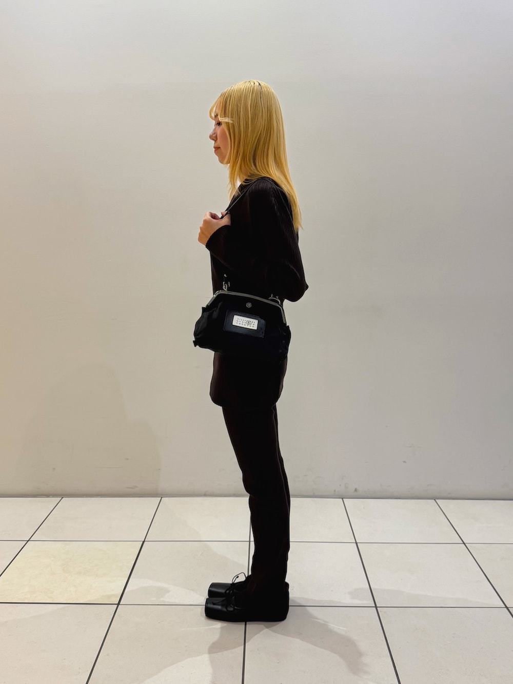ブラウン系のニット/セーター、ブラウン系のその他パンツ、ブラック系のショルダーバッグを着用したレディースの秋コーディネートの2枚目の写真