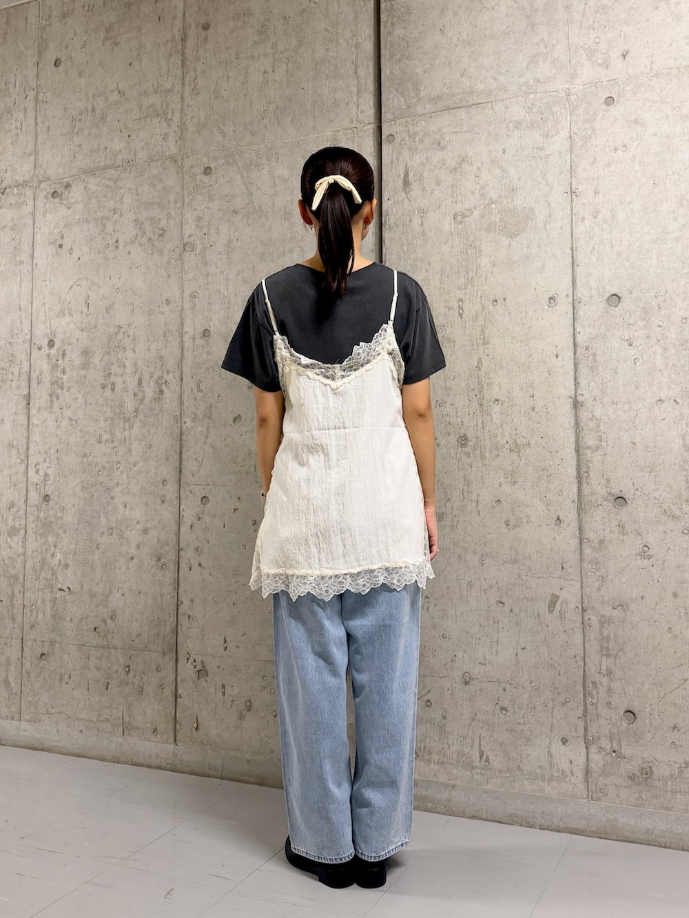 グレー系のTシャツ/カットソー、ブルー系のデニムパンツ、ホワイト系のキャミソールを着用したレディースの夏コーディネートの3枚目の写真