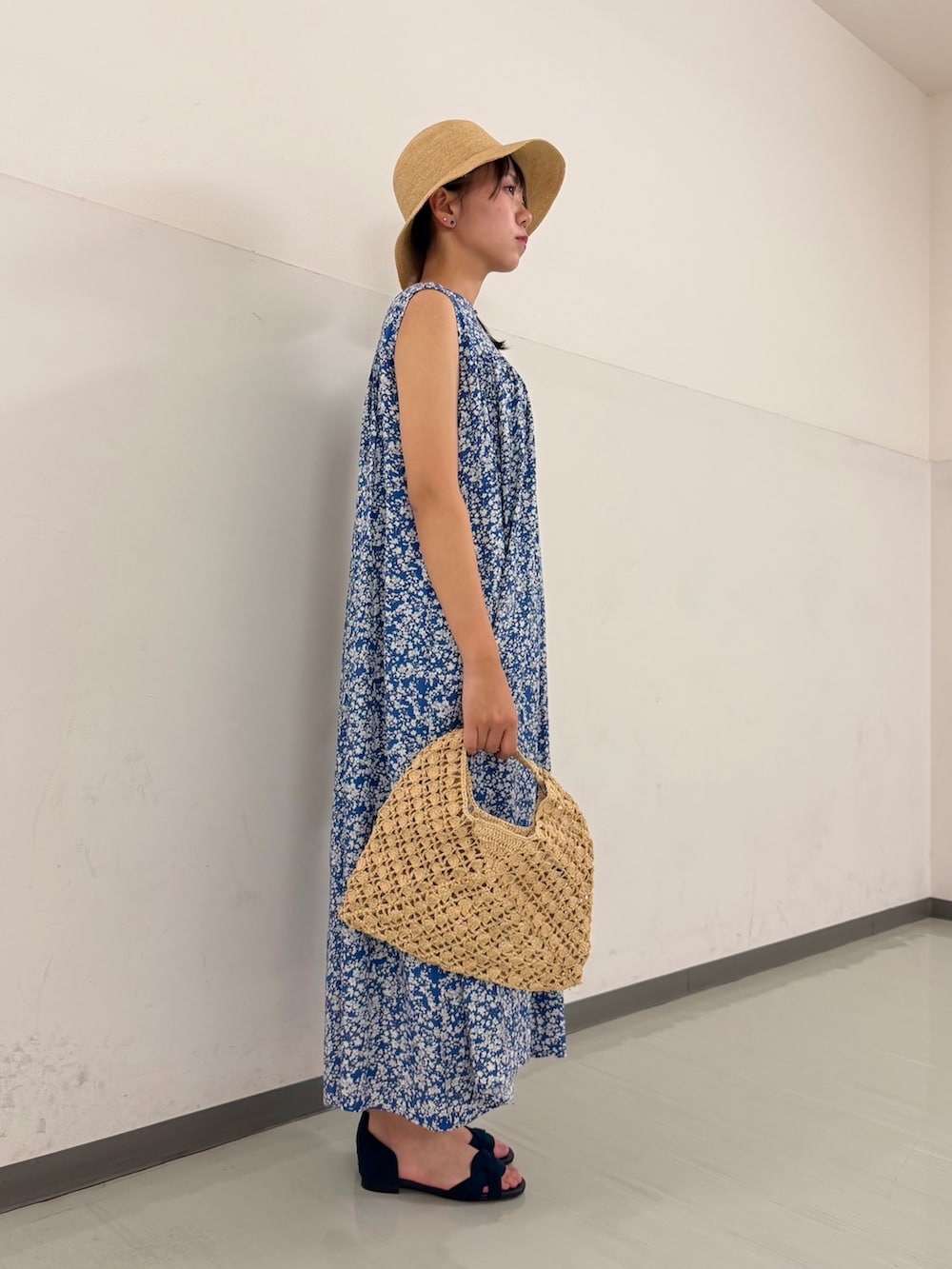 ブルー系のワンピース、ベージュ系のハンドバッグ、ブルー系のサンダルを着用したレディースの夏コーディネートの3枚目の写真