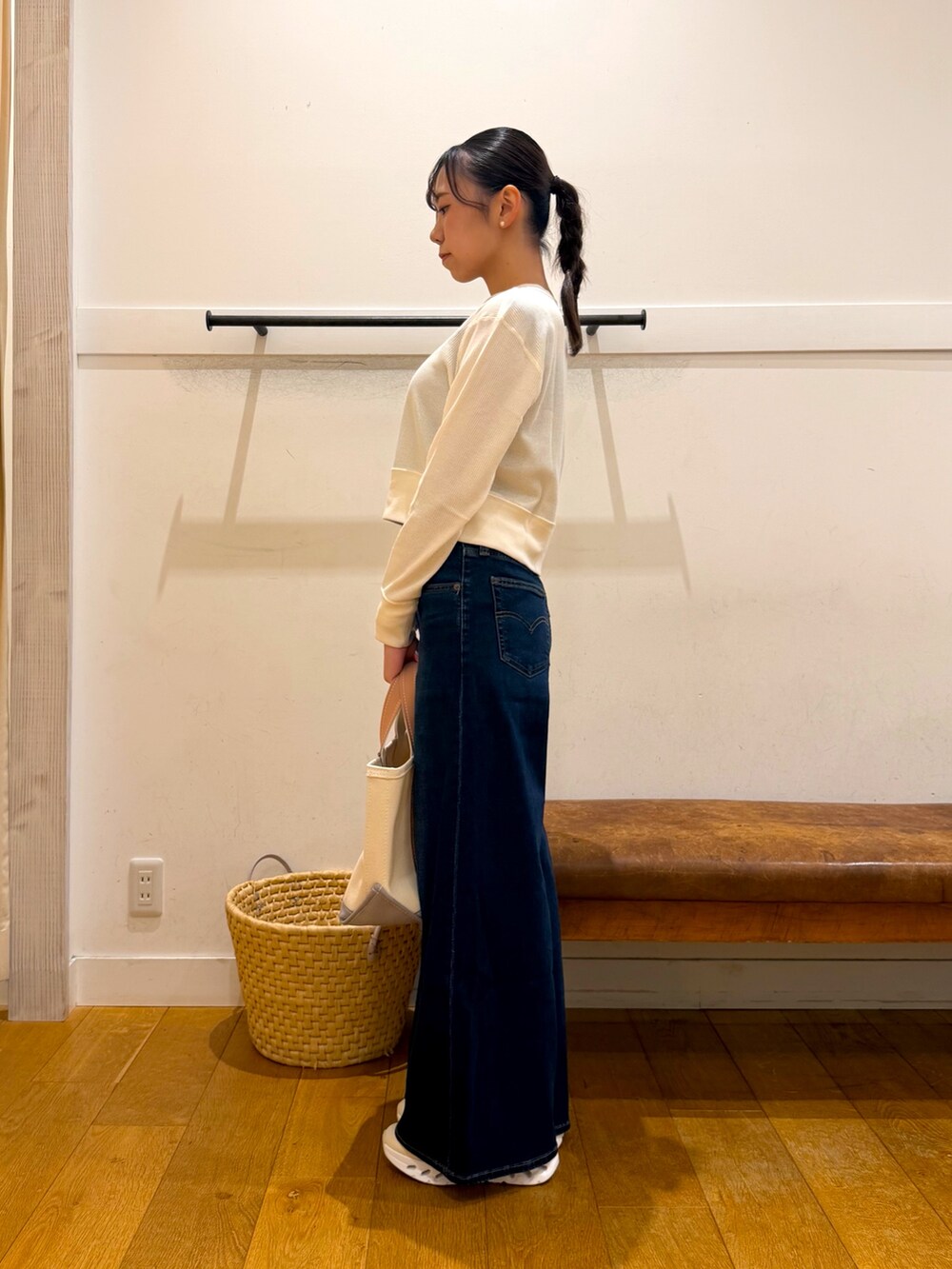 ホワイト系のカーディガン/ボレロ、ブルー系のデニムパンツ、ベージュ系のトートバッグを着用したレディースの秋コーディネートの3枚目の写真