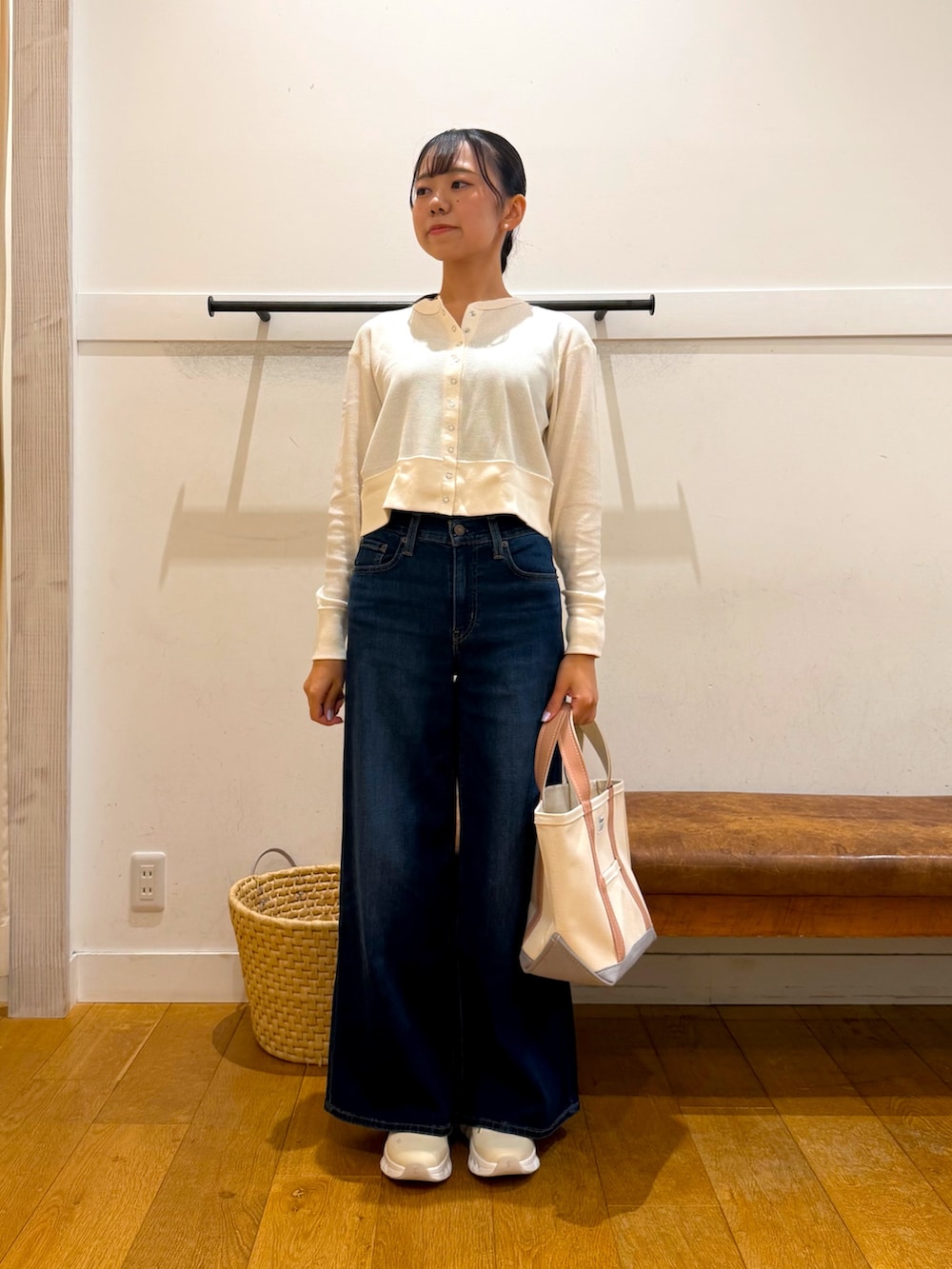 ホワイト系のカーディガン/ボレロ、ブルー系のデニムパンツ、ベージュ系のトートバッグを着用したレディースの秋コーディネートの5枚目の写真