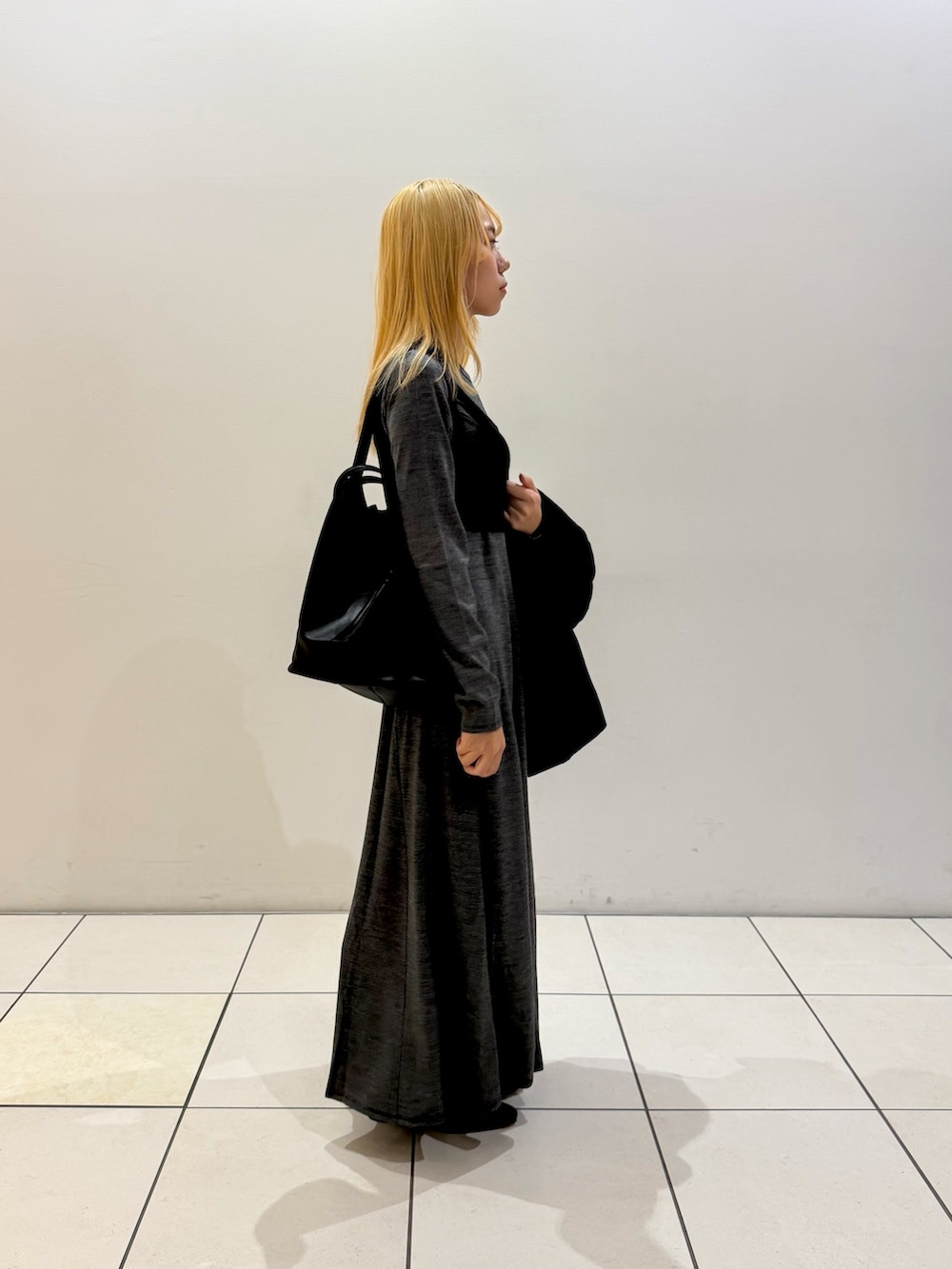 ブラック系のニット/セーター、ブラック系のブーツ、ブラック系のその他アウターを着用したレディースの秋コーディネートの2枚目の写真