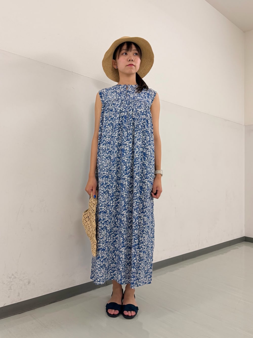 ブルー系のワンピース、ベージュ系のハンドバッグ、ブルー系のサンダルを着用したレディースの夏コーディネートの2枚目の写真