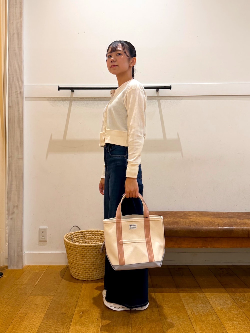 ホワイト系のカーディガン/ボレロ、ブルー系のデニムパンツ、ベージュ系のトートバッグを着用したレディースの秋コーディネートの2枚目の写真