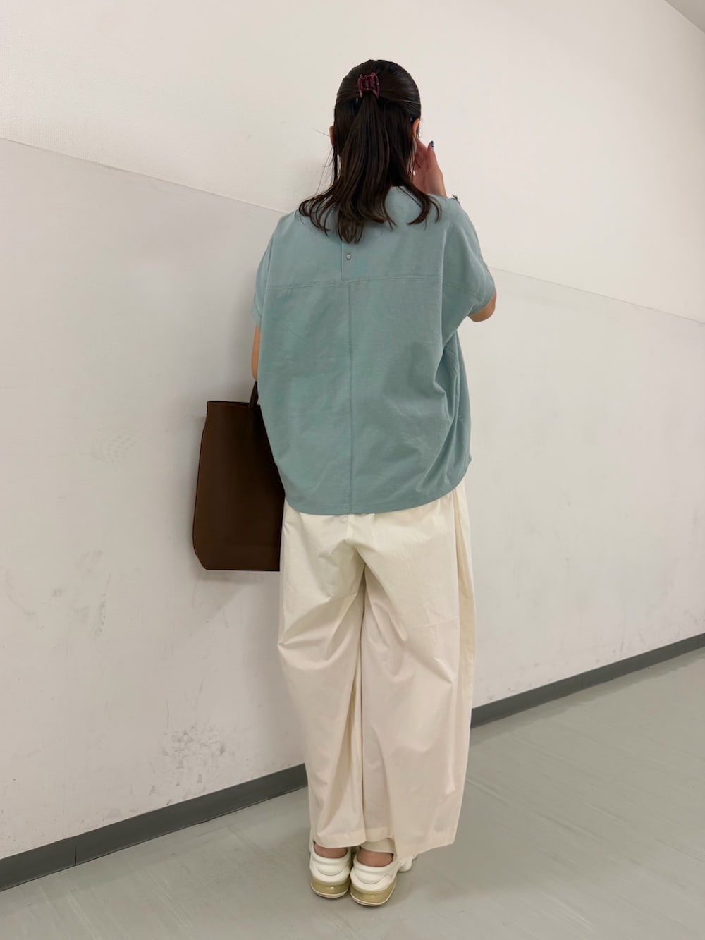 グリーン系のTシャツ/カットソー、ホワイト系のその他パンツ、ブラウン系のトートバッグを着用したレディースの夏コーディネートの3枚目の写真