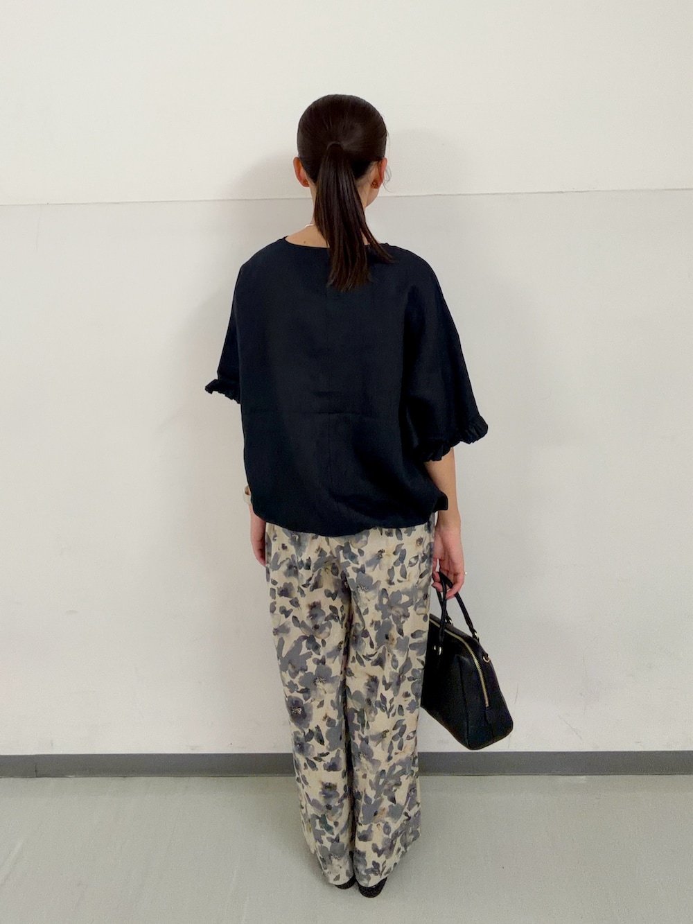 ブラック系のシャツ/ブラウス、グレー系のその他パンツ、ブラック系のボストンバッグを着用したレディースの春コーディネートの3枚目の写真