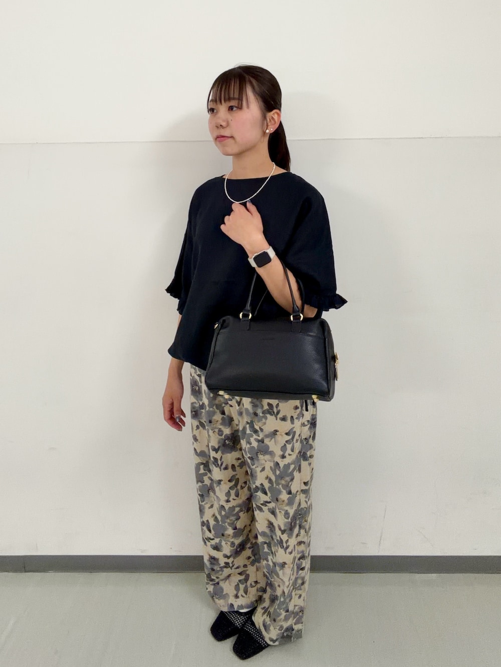 ブラック系のシャツ/ブラウス、グレー系のその他パンツ、ブラック系のボストンバッグを着用したレディースの春コーディネートの2枚目の写真