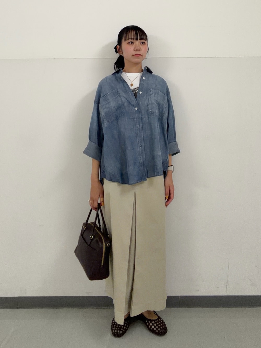 ブルー系のシャツ/ブラウス、ホワイト系のTシャツ/カットソー、ベージュ系のスカートを着用したレディースの春コーディネートの4枚目の写真