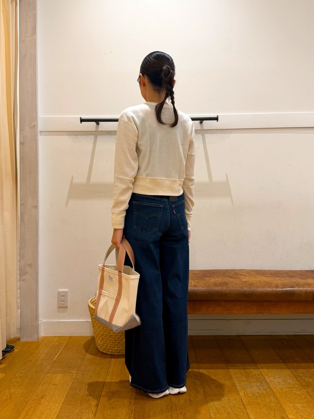 ホワイト系のカーディガン/ボレロ、ブルー系のデニムパンツ、ベージュ系のトートバッグを着用したレディースの秋コーディネートの4枚目の写真