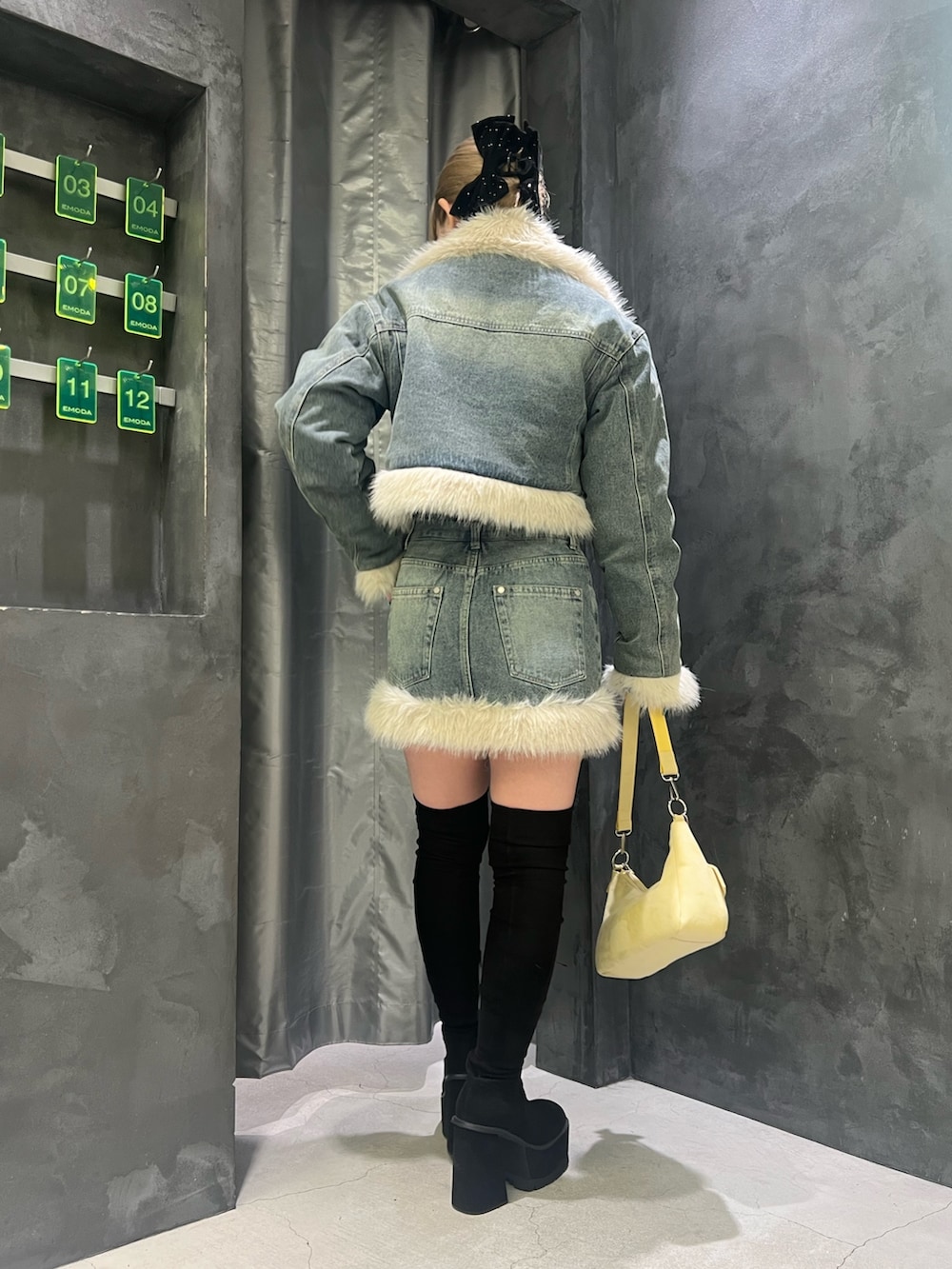 ブラック系のブーツ、イエロー系のショルダーバッグ、ブラック系のニット/セーターを着用したレディースの秋コーディネートの3枚目の写真