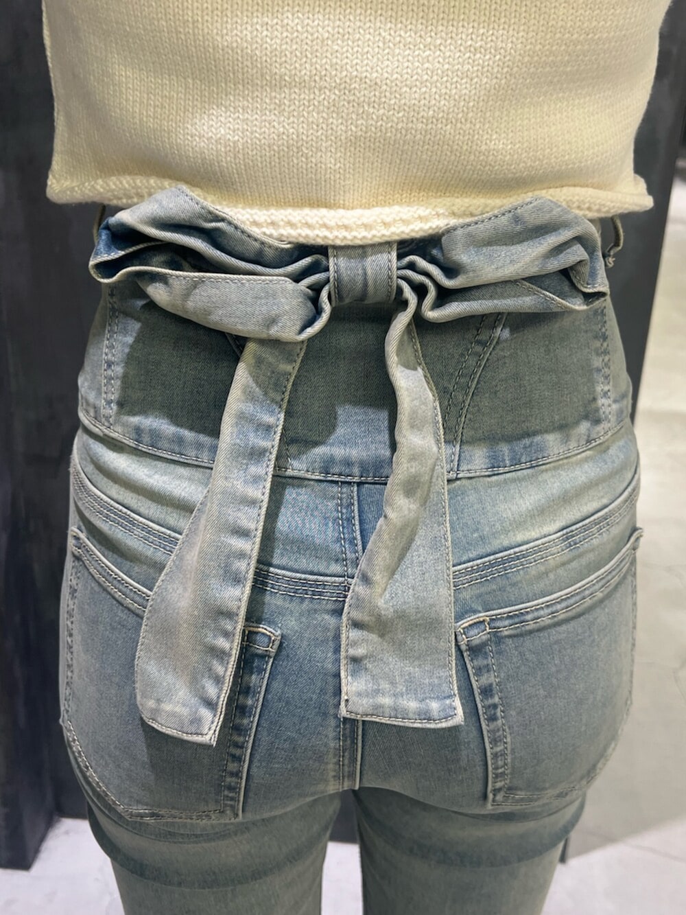 ブラック系のサンダル、ブルー系のデニムパンツ、ブラウン系のショルダーバッグを着用したレディースの夏コーディネートの4枚目の写真
