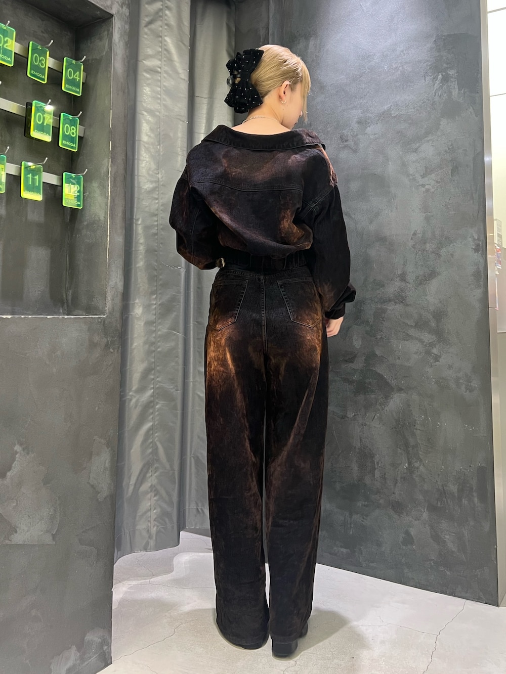 ブラウン系のデニムパンツ、ブラック系のサンダル、ブラウン系のブルゾンを着用したレディースの夏コーディネートの3枚目の写真