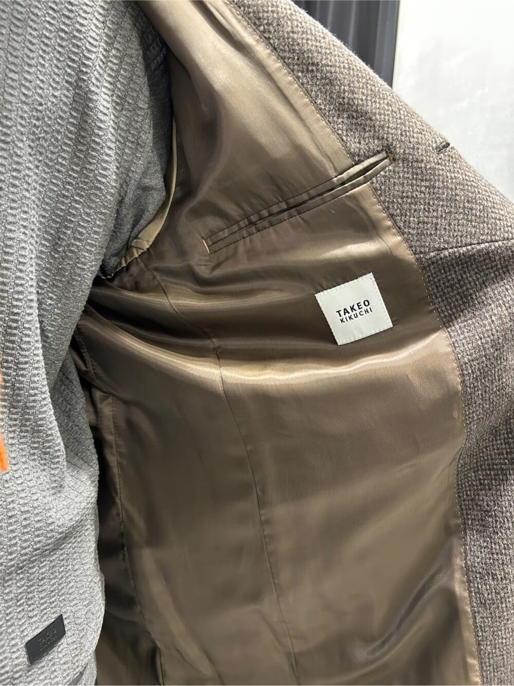 ブラウン系のその他アウター、グレー系のニット/セーター、オレンジ系のマフラーを着用したメンズの秋コーディネートの6枚目の写真