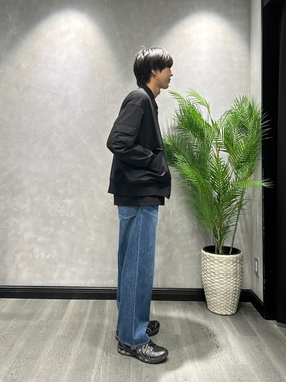ブラック系のブルゾン、ブラック系のTシャツ/カットソー、ブルー系のデニムパンツを着用したメンズの春コーディネートの2枚目の写真