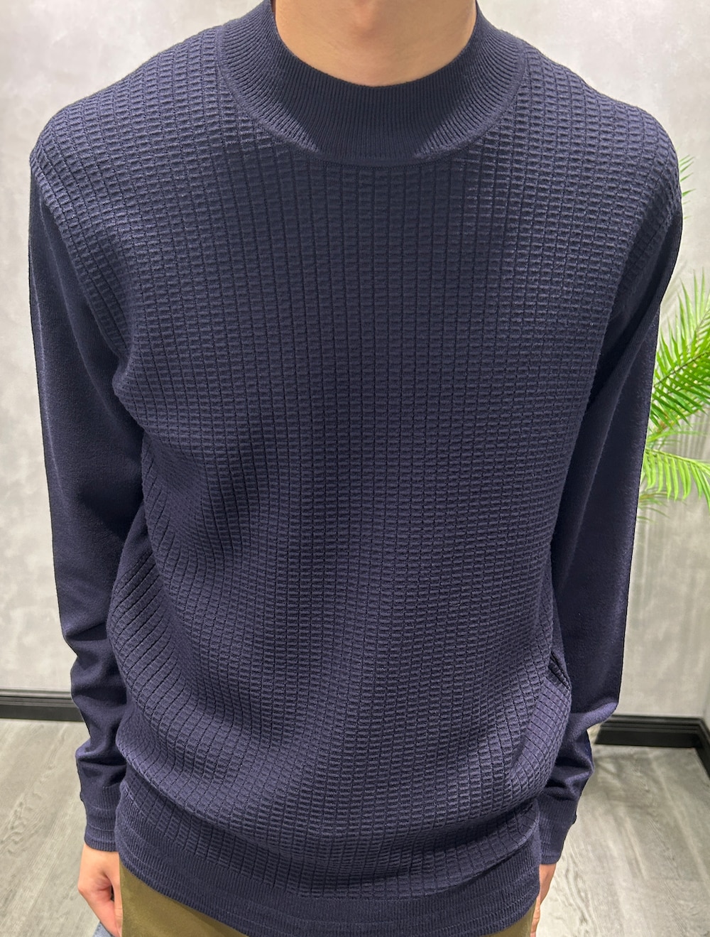 ブラック系のカーディガン/ボレロ、ブルー系のニット/セーター、グリーン系のスラックスを着用したメンズの秋コーディネートの8枚目の写真