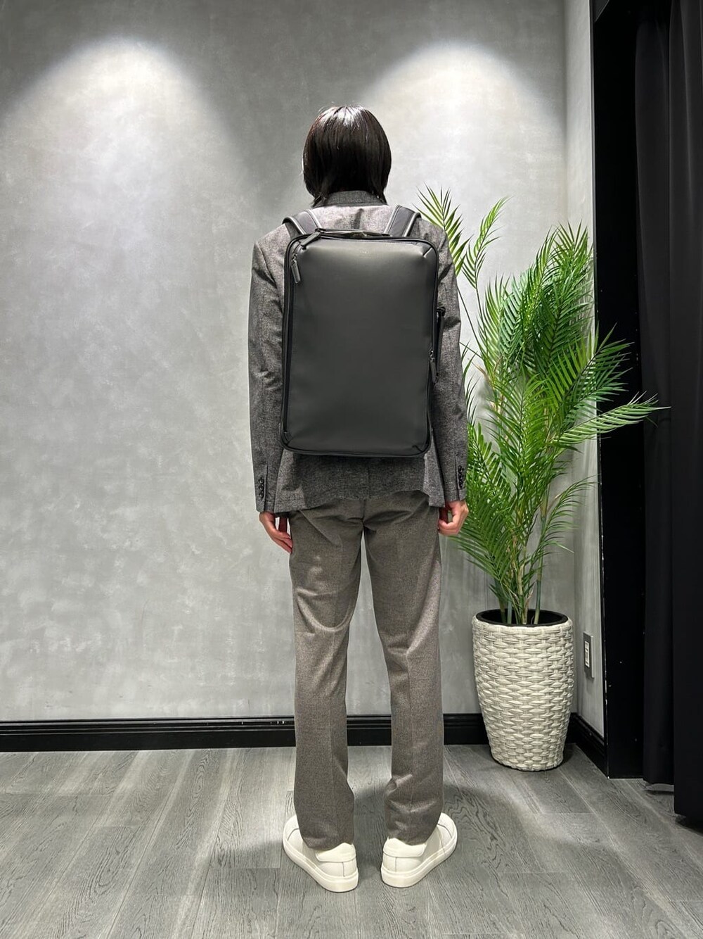 ブラック系のテーラードジャケット、ブラック系のスラックス、グレー系のバックパック/リュックを着用したメンズの夏コーディネートの3枚目の写真